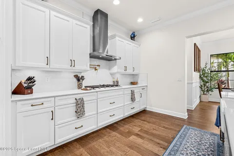 a kitchen with white cabinets and sink