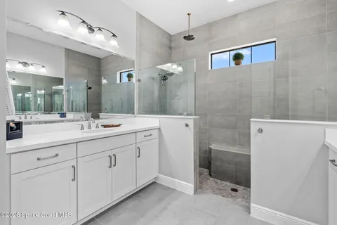 a bathroom with a double vanity sink mirror and shower