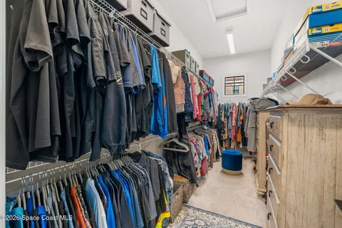 a view of walk in closet with clothes