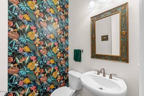 a bathroom with a sink mirror and toilet