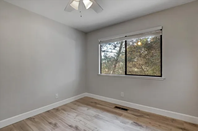 a view of a livingroom with wooden floor and a ceiling fan