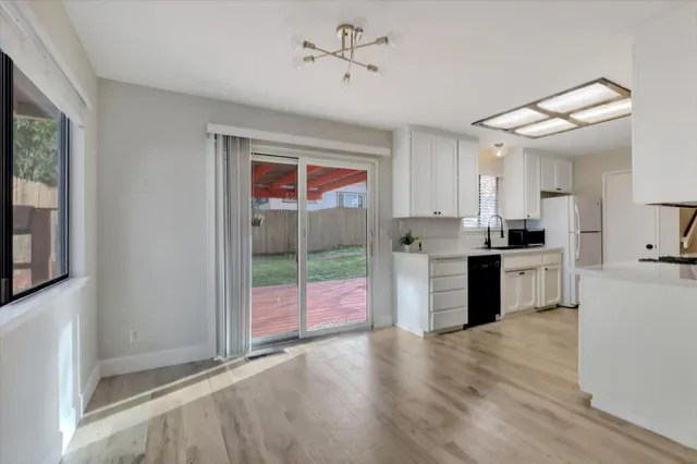 a kitchen with granite countertop a sink cabinets and stainless steel appliances
