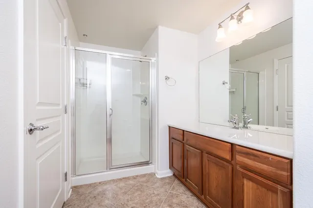 a spacious bathroom with a shower sink and mirror