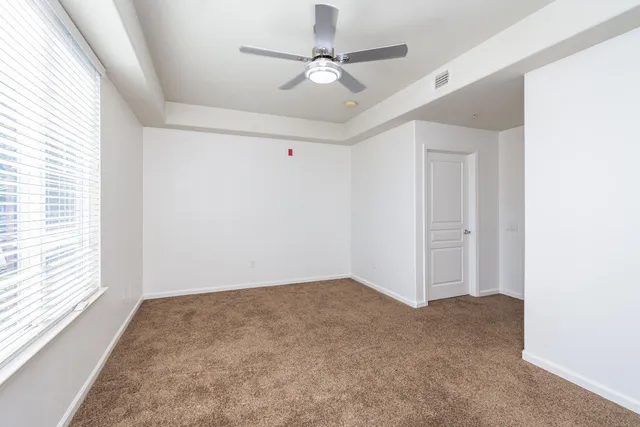 a view of a room with a ceiling fan and a window