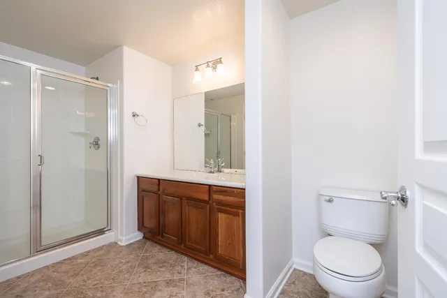 a spacious bathroom with a granite countertop toilet a sink and a mirror