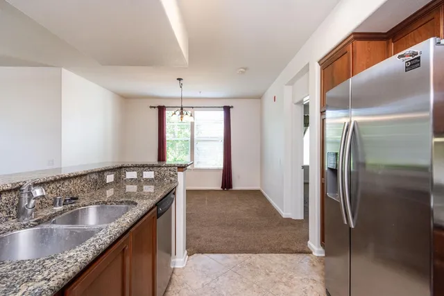 a kitchen with granite countertop a sink and a refrigerator