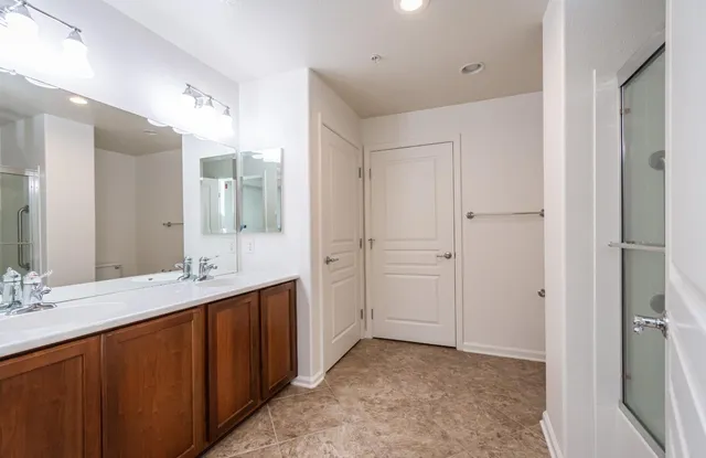 a bathroom with a double vanity sink mirror and shower