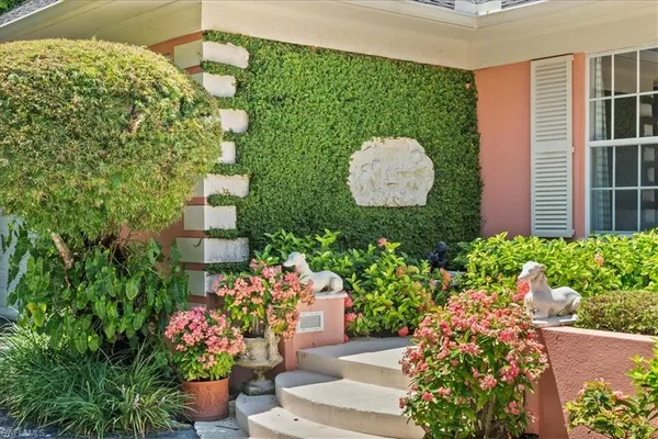 a front view of a house with a yard and fountain