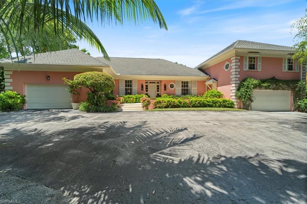 Undisclosed Address Naples, FL 34102 - Photo 3 of 22 a front view of a house with a garden