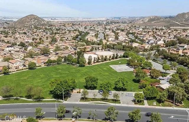 an aerial view of residential houses with outdoor space and trees