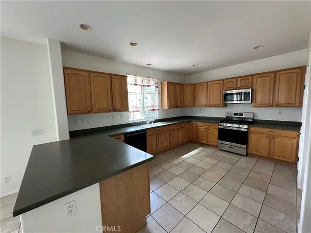 a kitchen with granite countertop a sink a counter top space and cabinets