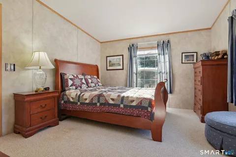 a bedroom with a bed dresser and a window