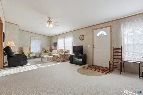 a living room with furniture a flat screen tv and couches