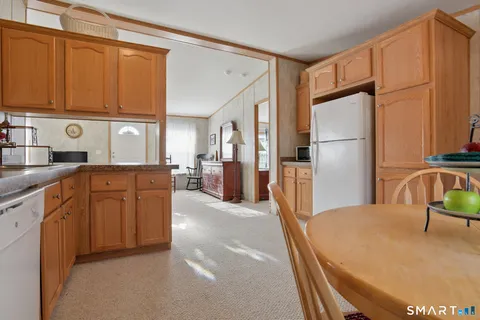 a kitchen with stainless steel appliances granite countertop a refrigerator a stove and a sink with cabinets