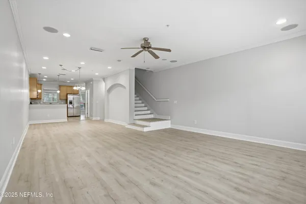 a view of a room with wooden floor and ceiling fan
