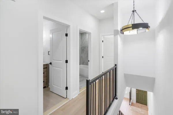 a view of a hallway with wooden floor and staircase