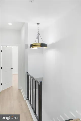 a view of a hallway with wooden floor and staircase