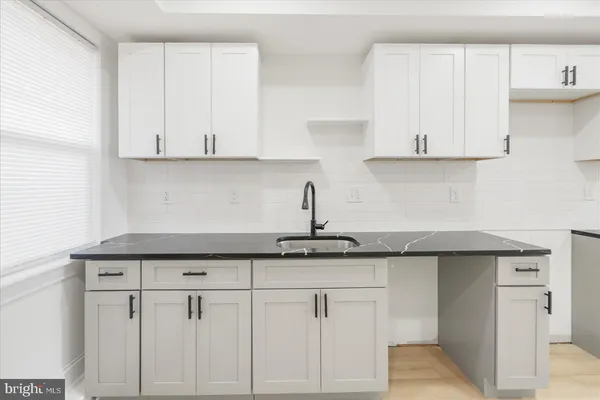 a kitchen with white cabinets and a sink