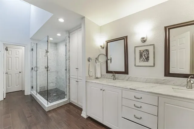 a spacious bathroom with double vanity sink a mirror and a shower