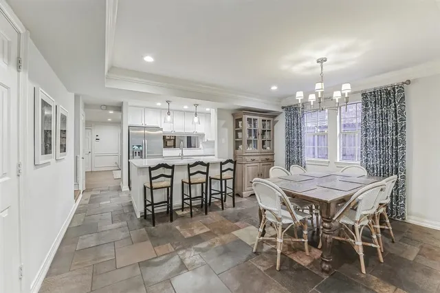 a dining area with a table chairs and a kitchen