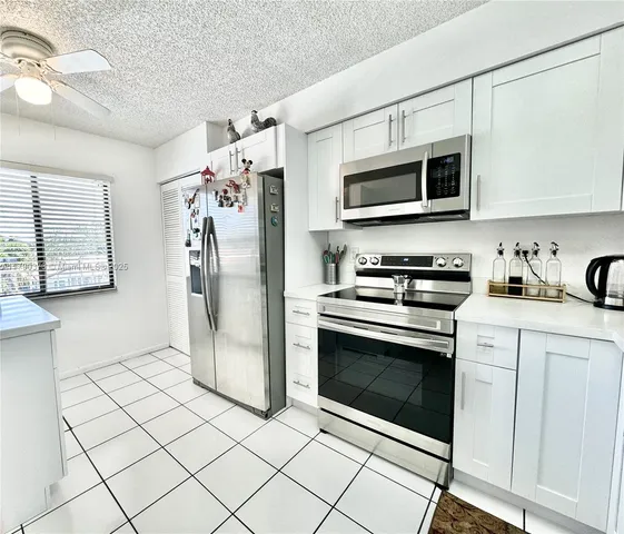 a kitchen with stainless steel appliances granite countertop a refrigerator microwave and sink