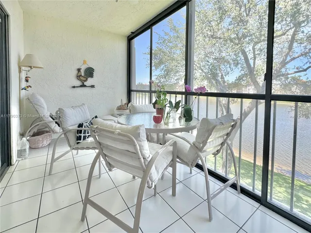 a dining room with furniture and large windows