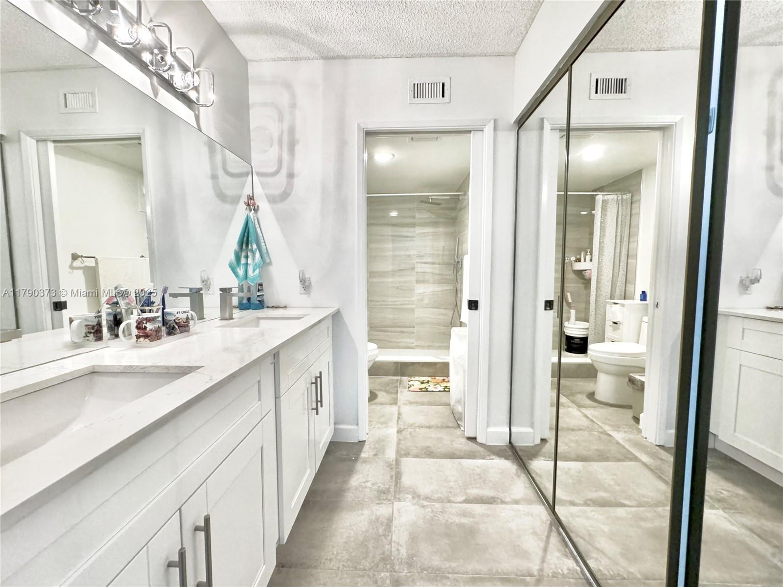 6193 Pointe Regal Circle, Unit 304 Delray Beach, FL 33484 - Photo 6 of 15 a bathroom with a double vanity sink and a mirror