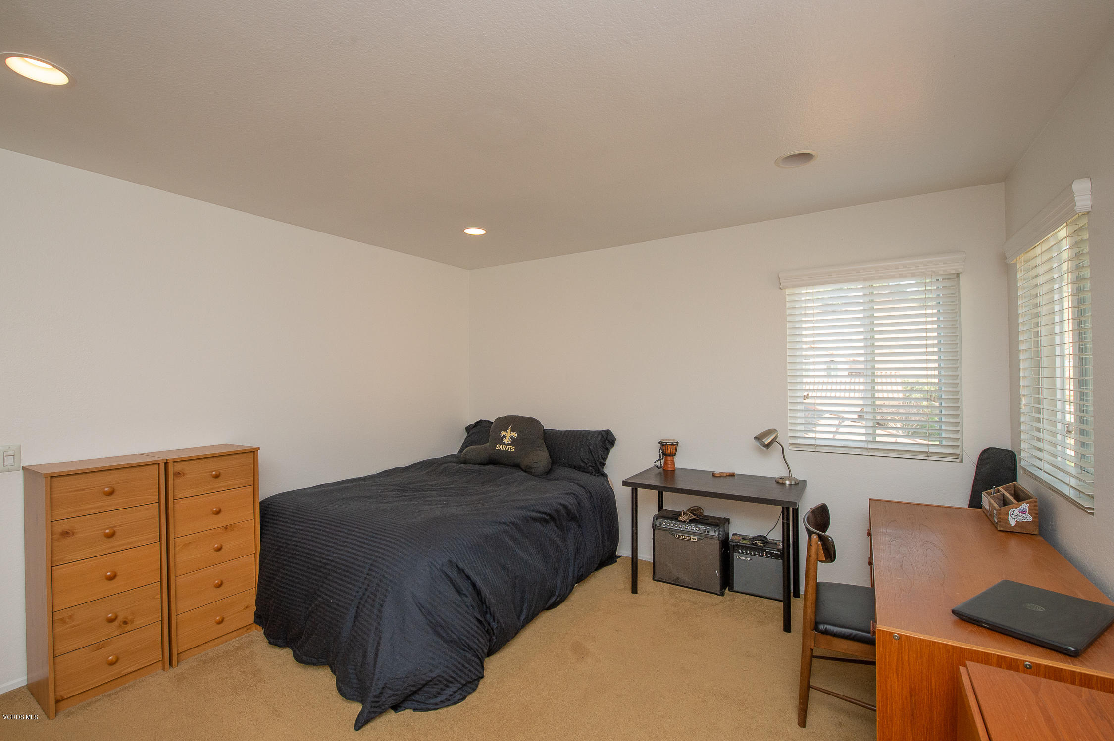 7354 Griffith Lane Moorpark, CA 93021 - Photo 33 of 53 a bedroom with a bed a table and a dresser next to a window