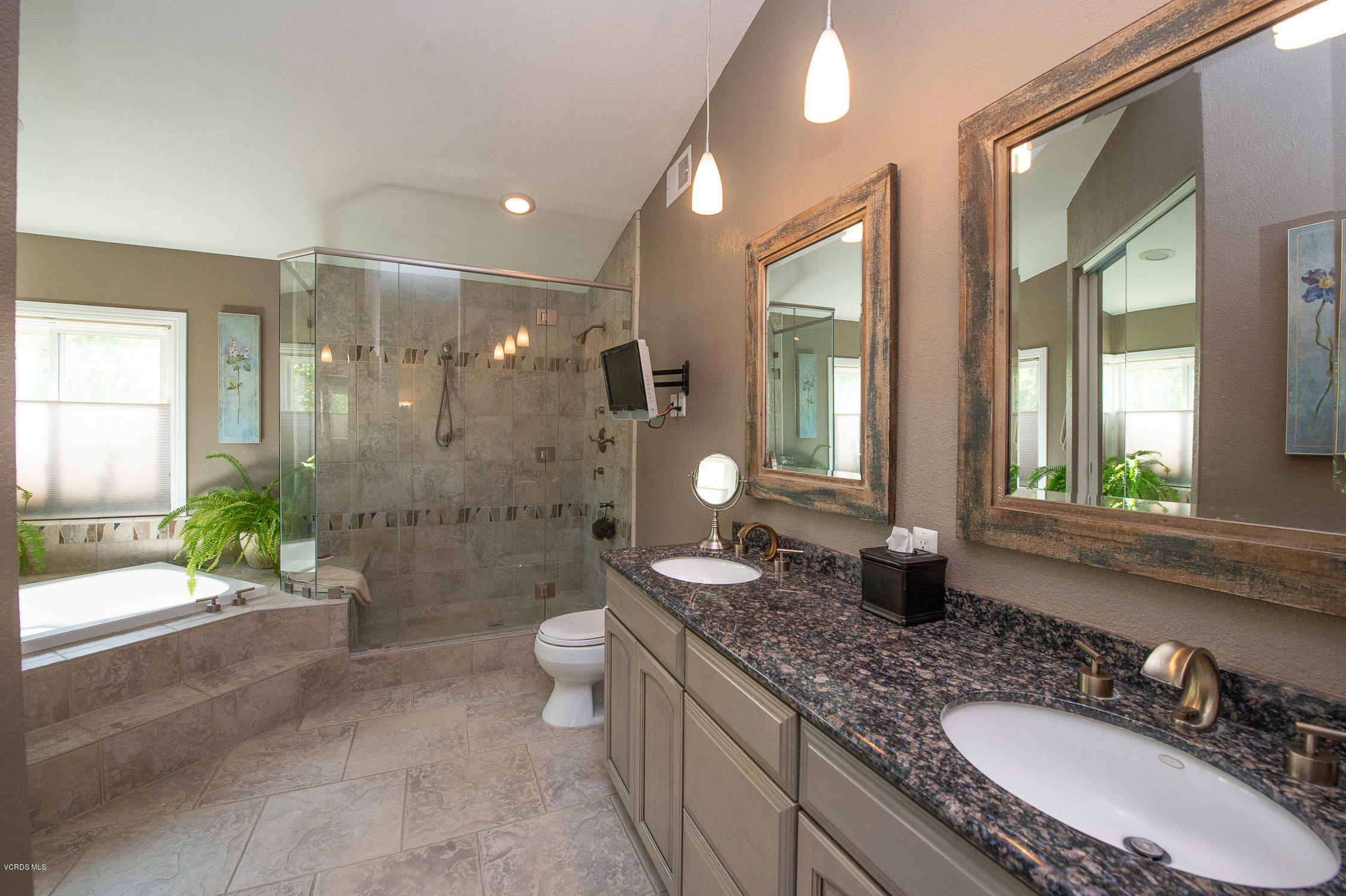 7354 Griffith Lane Moorpark, CA 93021 - Photo 41 of 53 a bathroom with a granite countertop sink a toilet a mirror a bathtub and shower