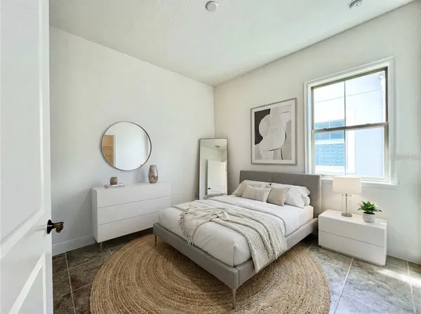 a bedroom with a bed mirror and window