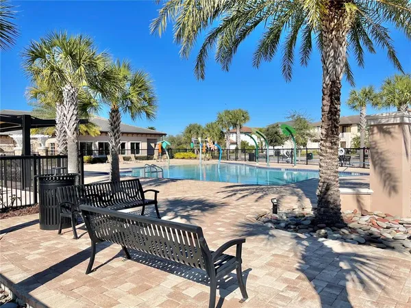 a view of a swimming pool with a table and chairs under an umbrella