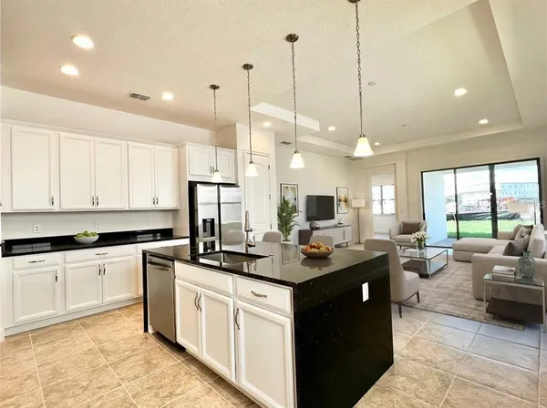 a kitchen with stainless steel appliances granite countertop a sink a stove and a wooden floors