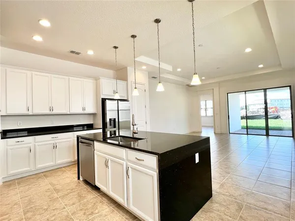 a kitchen with granite countertop a sink a counter top space appliances and cabinets