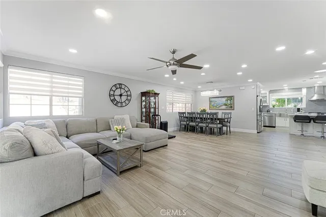 a living room with furniture a wooden floor and a large window