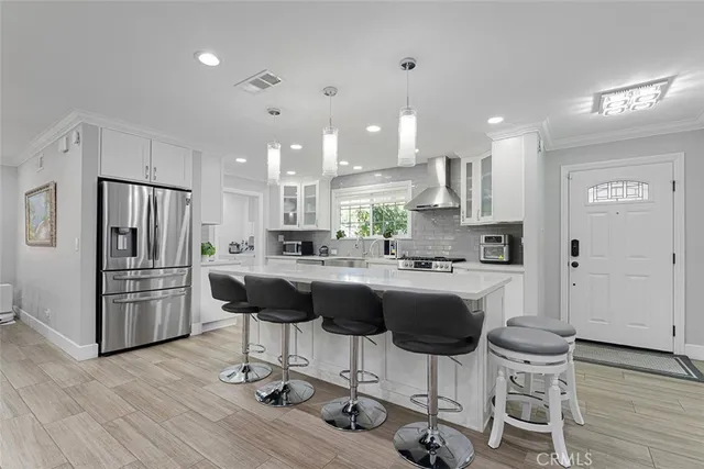 a kitchen with stainless steel appliances kitchen island granite countertop a refrigerator and a stove top oven