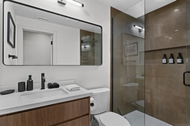 a bathroom with a sink a toilet and shower