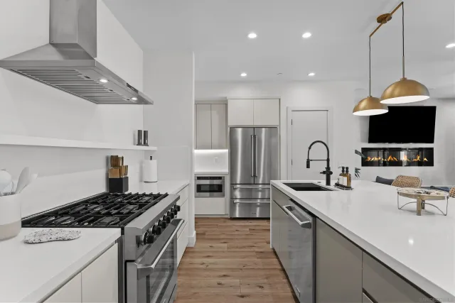 a kitchen with refrigerator a stove and a sink