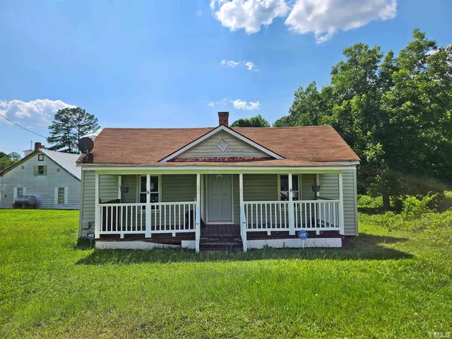 a view of a house with a yard and deck