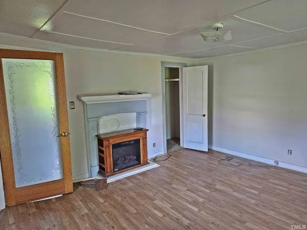 a view of empty room with wooden floor and fireplace