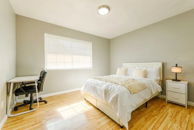 a bedroom with a bed a table and chair