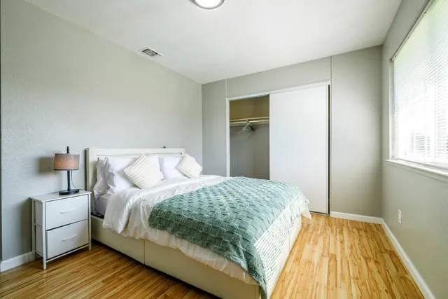 a bedroom with a bed and wooden floor