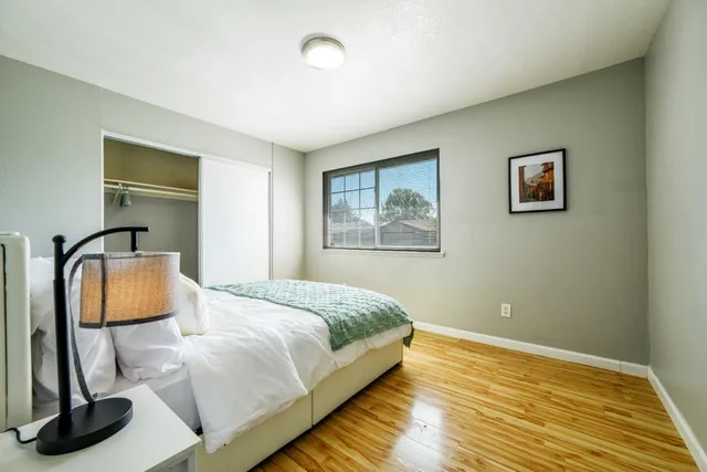 a bedroom with a bed and wooden floor