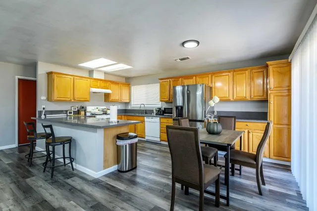 a dining room with a table chairs and kitchen view