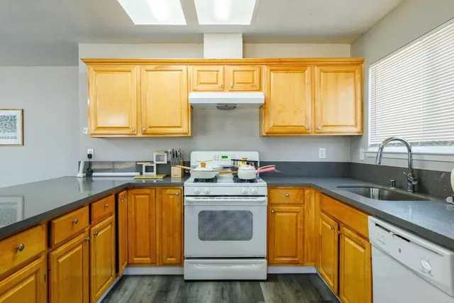 a kitchen with stainless steel appliances granite countertop a sink a stove and cabinets