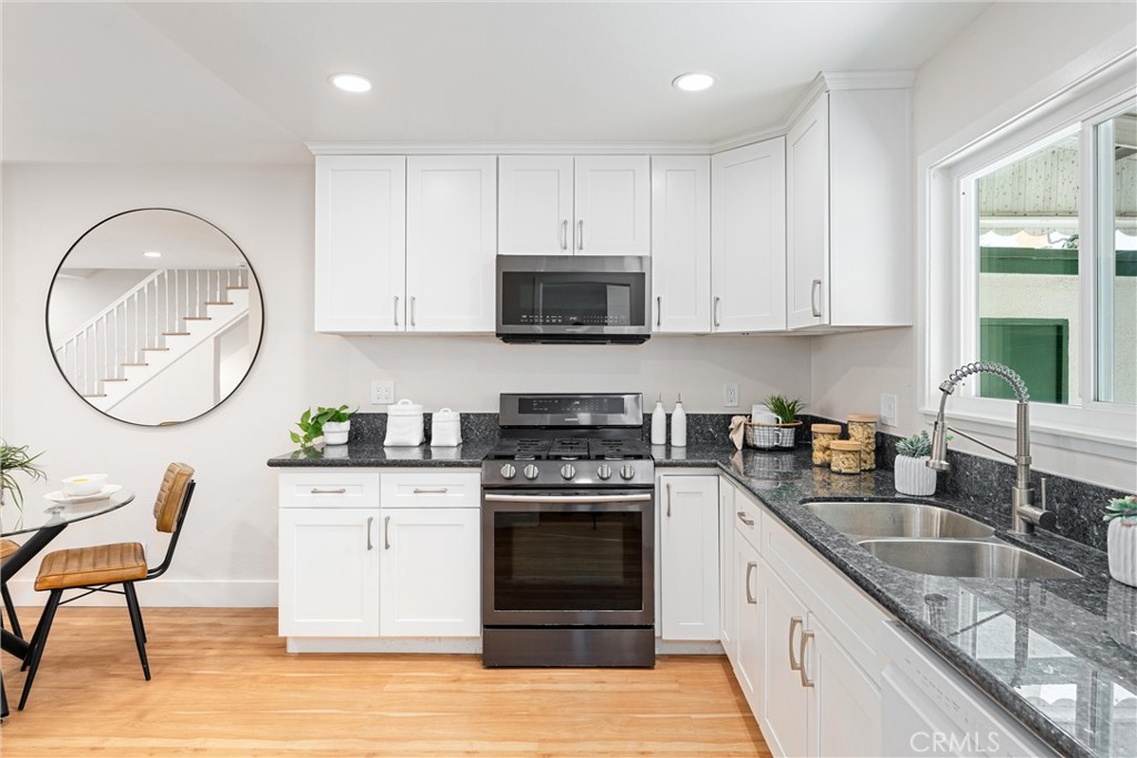 8236 Henderson Green Buena Park, CA 90621 - Photo 14 of 35 a kitchen with granite countertop a stove a sink and a wooden cabinets