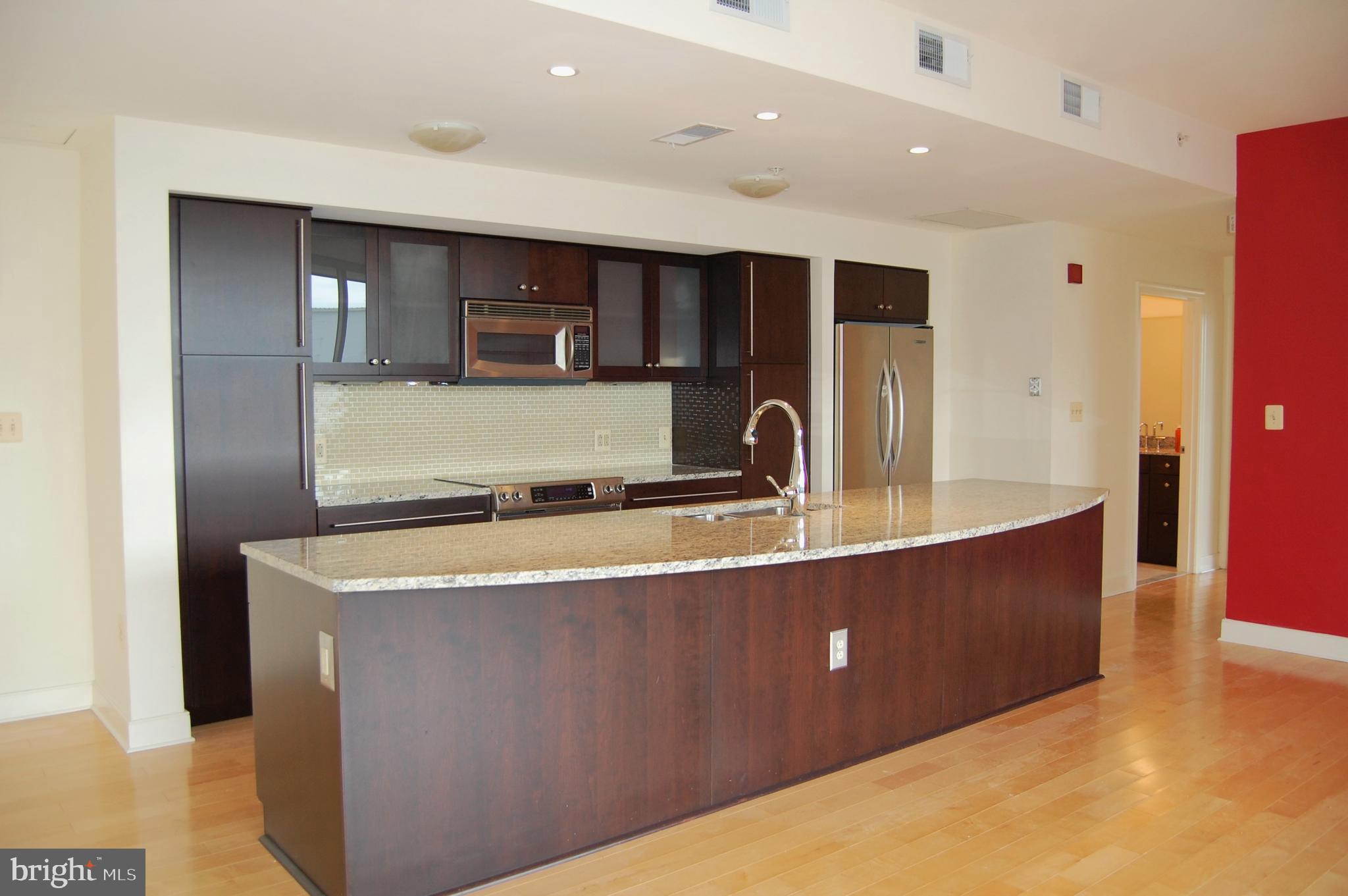 675 President Street, Unit 1609 Baltimore, MD 21202 - Photo 4 of 13 a large kitchen with stainless steel appliances a large counter top