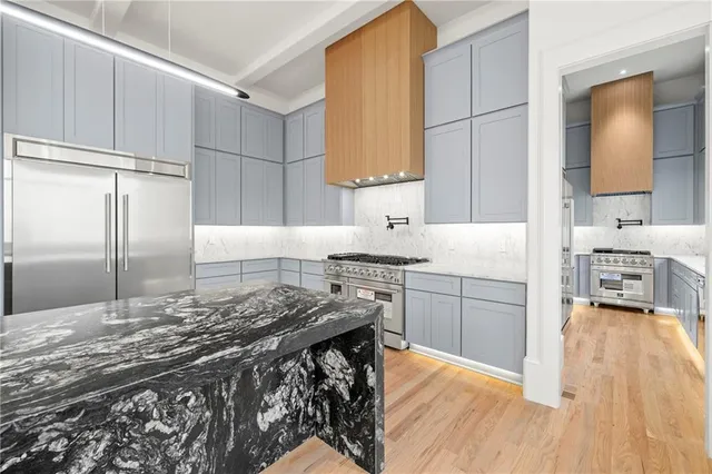 a view of an empty room with wooden floor and a fireplace
