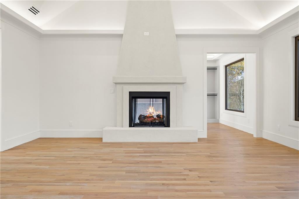 520 Heathmill Court Milton, GA 30004 - Photo 41 of 84 a view of an empty room with wooden floor and a fireplace