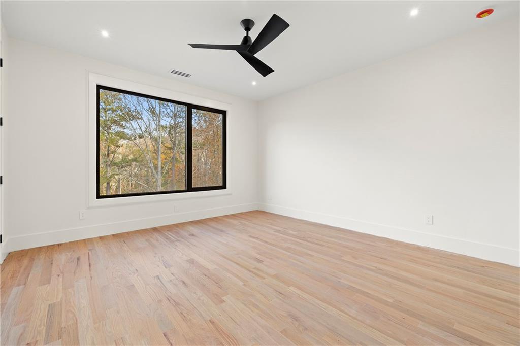 520 Heathmill Court Milton, GA 30004 - Photo 53 of 84 an empty room with wooden floor ceiling fan and windows