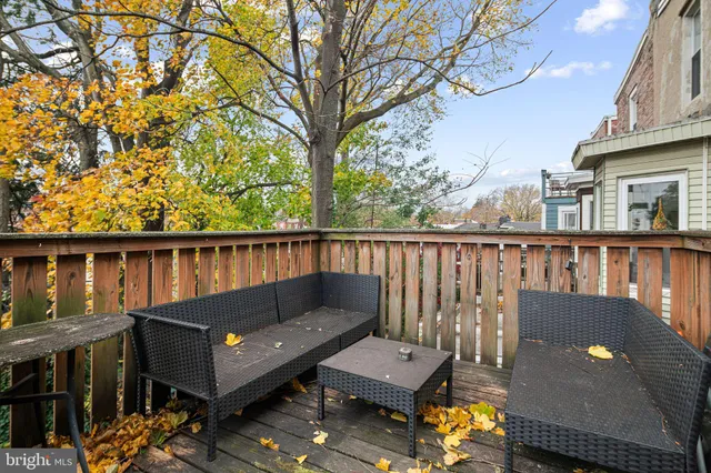 a balcony with wooden floor and outdoor seating